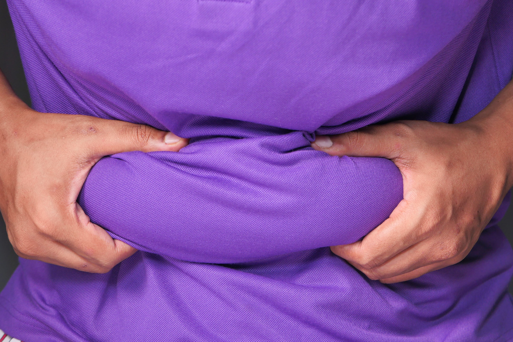 Man's Hand Holding Excessive Belly Fat, Overweight Concept